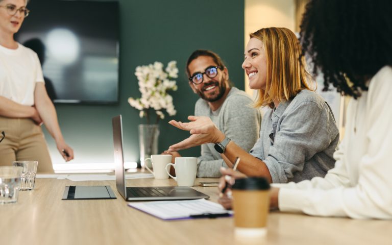 Employee-benefits-Ireland-employee-experience Business woman talking to her colleagues during a meeting in a boardroom