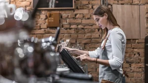 Lady operating the payment machine in a cafe