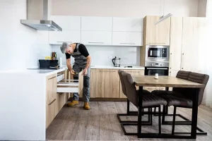 Tradesperson fixing kitchen in housing association property