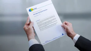 Businessperson's hands holding a copy of the NelsonHall report in which Zellis was named as a leader